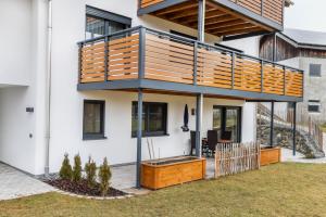 a house with a deck on the side of it at Ferienwohnung Alpenvorland in Seeg