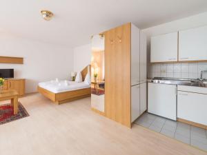 a kitchen with white cabinets and a living room at Fewo Schneckenhalde App 12 in Bad Säckingen