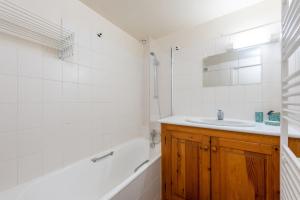 a bathroom with a sink and a tub and a mirror at Gîte Centre Luz-Saint-Sauveur in Luz-Saint-Sauveur +17 photos
