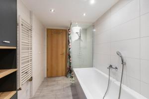 a bathroom with a bath tub and a shower at Ferienhaus Am Reiterhof in Templin +21 photos