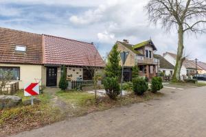 a house with a red arrow sign in front of it at Ferienhaus Am Reiterhof in Templin