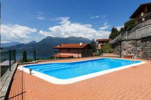 a swimming pool in front of a house at Magic moment in Lake Como in Perledo