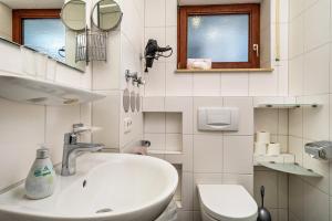 a bathroom with a sink and a toilet at Gästehaus Heinemann - Eg3 in Langenargen +23 photos