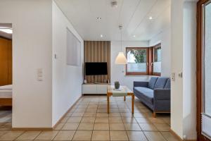 a living room with a couch and a tv at Gästehaus Heinemann - Eg3 in Langenargen