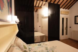 a bedroom with a mirror and a bed in a room at Romantica Corte Degli Estensi in Ferrara