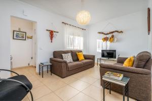 a living room with two couches and a tv at Casa Quintião in Ferragudo