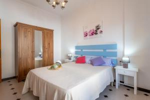 a bedroom with a large white bed with colorful pillows at Cas Cover in Santa Margalida