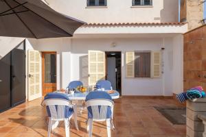 a patio with a table and chairs and an umbrella at Cas Cover in Santa Margalida