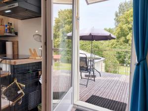 a sliding glass door leading to a deck with an umbrella at le Nid perché in Brou