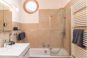 a bathroom with a shower and a sink and a tub at Das Bergzeit in Farchant +18 photos