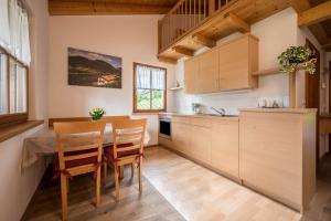 a kitchen with wooden cabinets and a table and chairs at Kreuzhof rechts in Novacella +14 photos