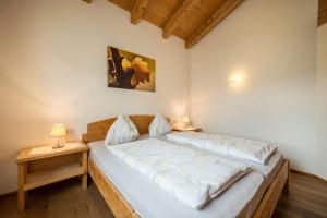 a bedroom with a large bed with a night stand at Kreuzhof rechts in Novacella