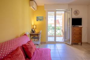 a room with a bed and a desk and a television at Appartement Stomolocation in Sainte-Maxime