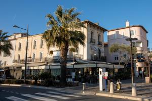 a city street with a palm tree and buildings at Appartement Stomolocation in Sainte-Maxime