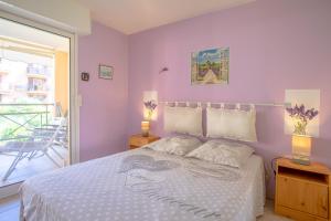a bedroom with a bed with two lamps and a balcony at Appartement Stomolocation in Sainte-Maxime