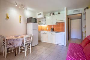 a kitchen with a table and a small kitchen with white appliances at Appartement Stomolocation in Sainte-Maxime