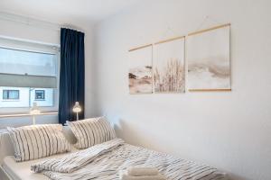a bedroom with a bed with three paintings on the wall at Fewokuh in Wilhelmshaven