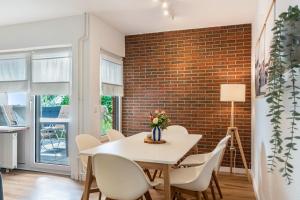 a dining room with a white table and chairs and a brick wall at Fewokuh in Wilhelmshaven