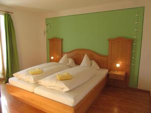 a bedroom with a bed with white sheets and yellow pillows at Zum Heisn in Lenggries