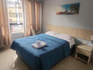 a hotel room with a bed with a blue blanket and a candle on it at Hospedaje costa pacífico in Chimbote