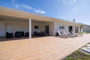 a large patio with chairs and a table on a house at Villa Lumière Ychoux in Ychoux