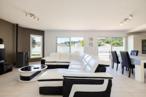 a living room with white furniture and a table at Villa Lumière Ychoux in Ychoux