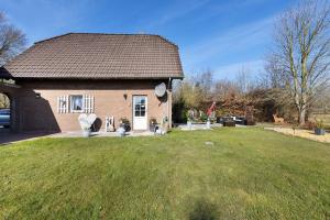 a small brick house with a grass yard at Ferienhaus Harmonie in Südbrookmerland