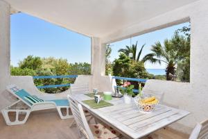 a table and chairs on a patio with a view of the ocean at Casa Vacanze Osala in Orosei