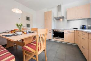 a kitchen with a wooden table and chairs in it at Suite Marianne in Valdaora