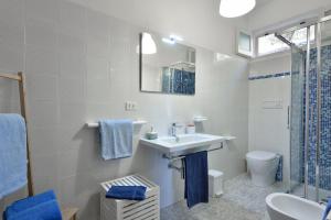a bathroom with a sink and a toilet and a mirror at Casa Vacanze Osala in Orosei