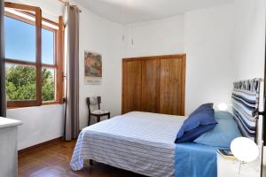 a bedroom with a bed and a window at Casa Vacanze Osala in Orosei