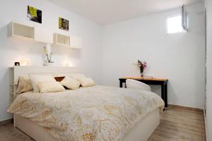 a white bedroom with a large bed and a table at Isla Lobos in Playa Blanca
