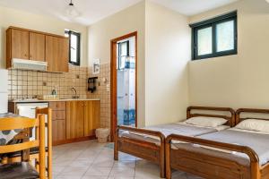 two beds in a room with a kitchen at Daratos apartment 6 in Kefallonia +14 photos