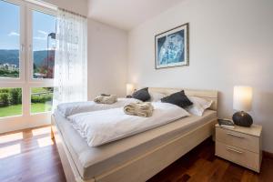 a white bedroom with a large bed and a window at Suite Marianne in Valdaora