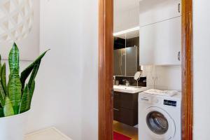 a kitchen with a washing machine and a plant at Isla and Ocean with pool and wifi in Costa Teguise