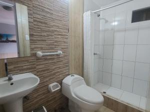 a bathroom with a toilet and a sink and a shower at Hospedaje costa pacífico in Chimbote