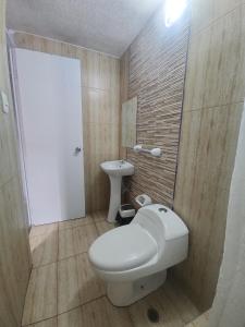 a small bathroom with a toilet and a sink at Hospedaje costa pacífico in Chimbote