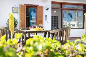 a table and chairs on a patio with a window at Isla and Ocean with pool and wifi in Costa Teguise