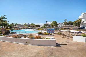a resort with a pool and tables and umbrellas at Isla and Ocean with pool and wifi in Costa Teguise