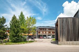 a building with a wooden wall next to a street at Chalet Hubertus in Kastelruth