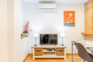 a living room with a television on a table at Tosca Mar 223 in Moraira