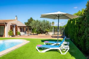 two lounge chairs and an umbrella next to a swimming pool at S'Hostalet in Islas Baleares