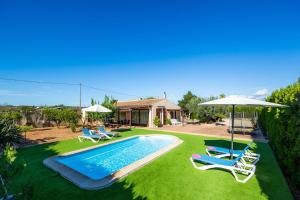 a yard with a swimming pool and two chairs and an umbrella at S'Hostalet in Islas Baleares +27 photos