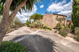 an empty road with a house and palm trees at Casa Pina in Costitx
