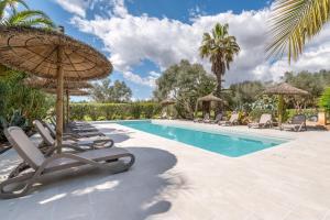 a swimming pool with chairs and an umbrella at Casa Pina in Costitx