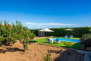 a swimming pool with two umbrellas and two chairs at S'Hostalet in Islas Baleares