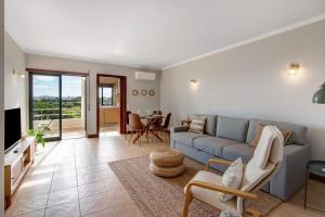 a living room with a blue couch and a table at Sunrise Salgados Village in Galé