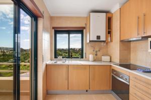 a kitchen with a sink and a large window at Sunrise Salgados Village in Galé +15 photos