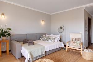 a bedroom with a bed and a chair at Sunrise Salgados Village in Galé