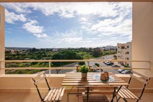 a balcony with a table and chairs and a view at Sunrise Salgados Village in Galé
